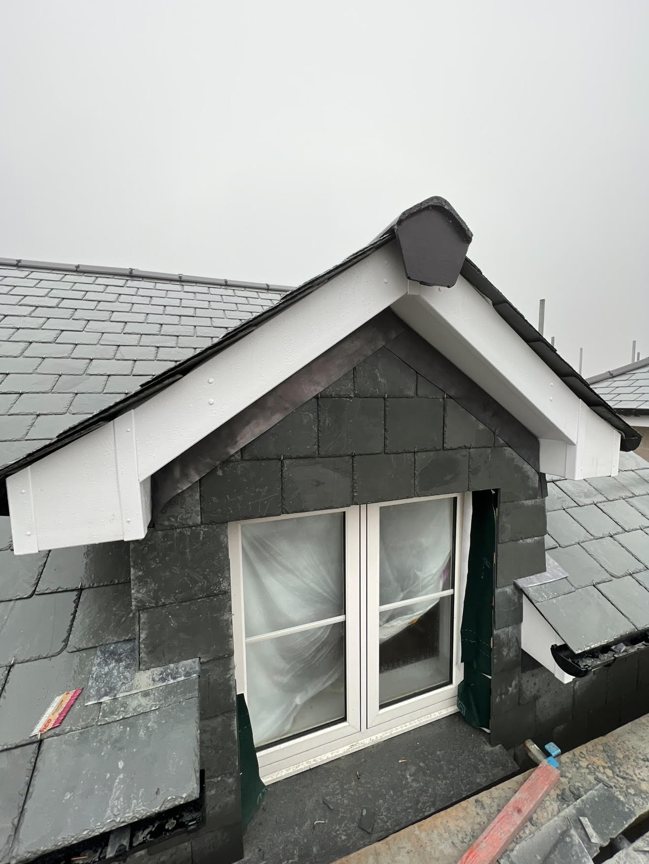 A dormer extension finished with vertical slate hung and crisp white bargeboards