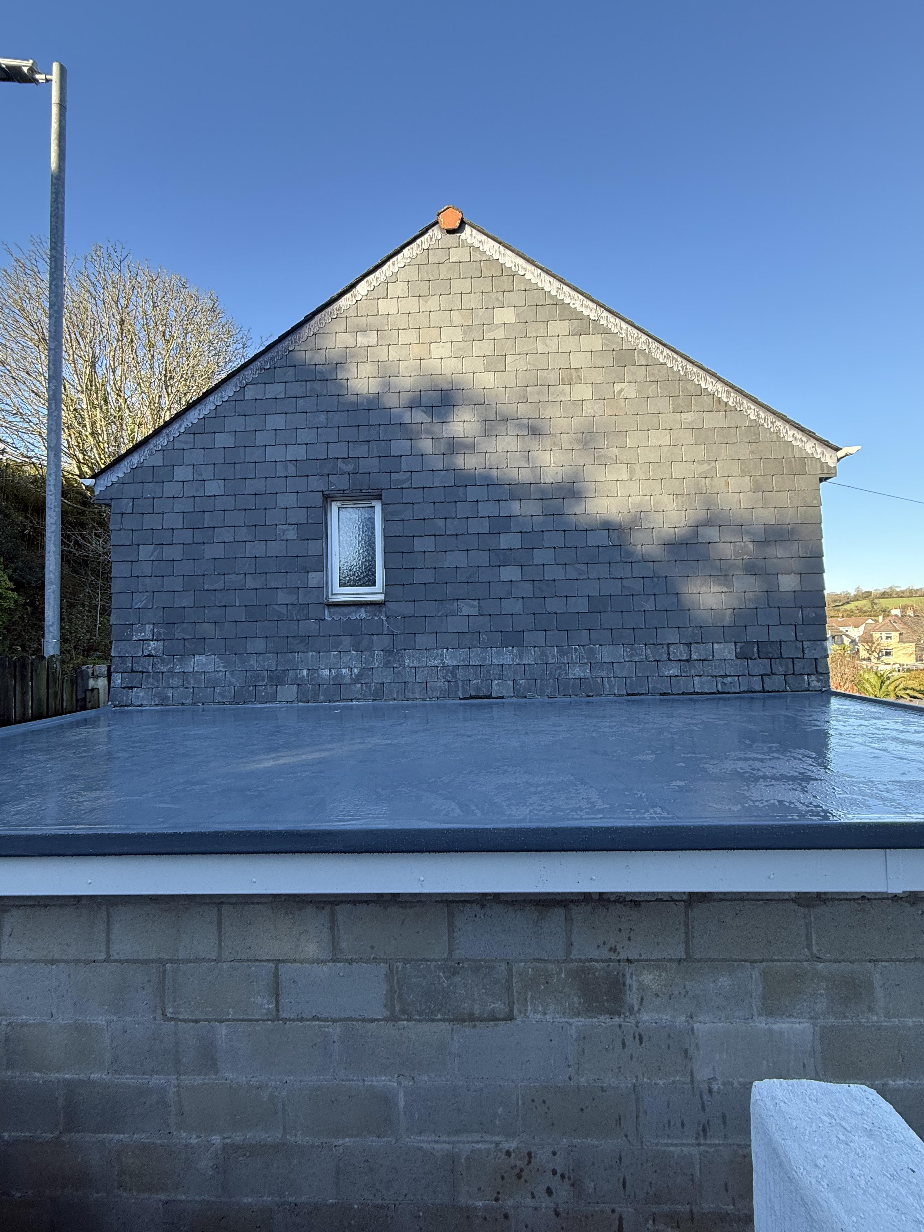 A new GRP flat roof on an extension, with slate replaced on the gable to make it watertight
