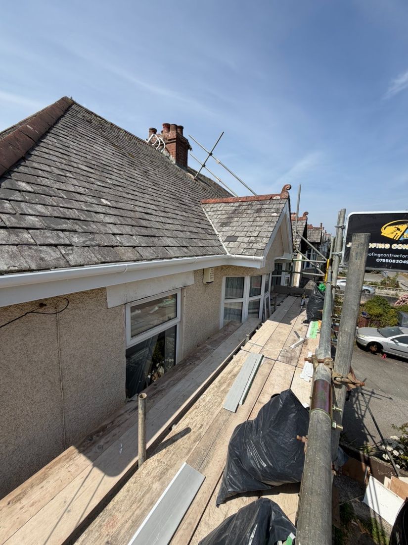 New fascia and guttering going on to the roofline of a two-storey house