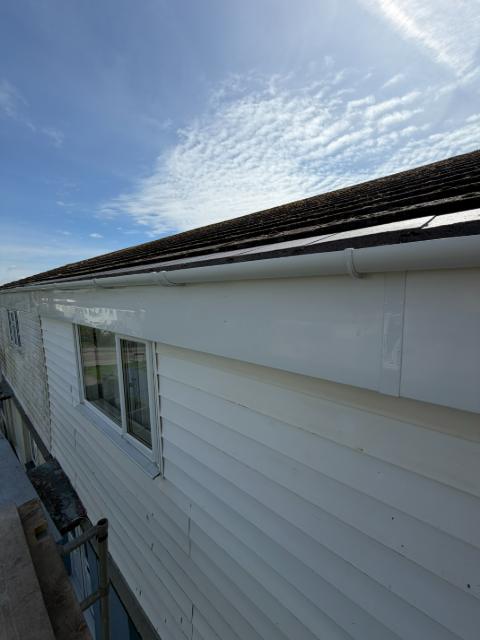 Crisp new white fascia, soffit and guttering running along a roofline