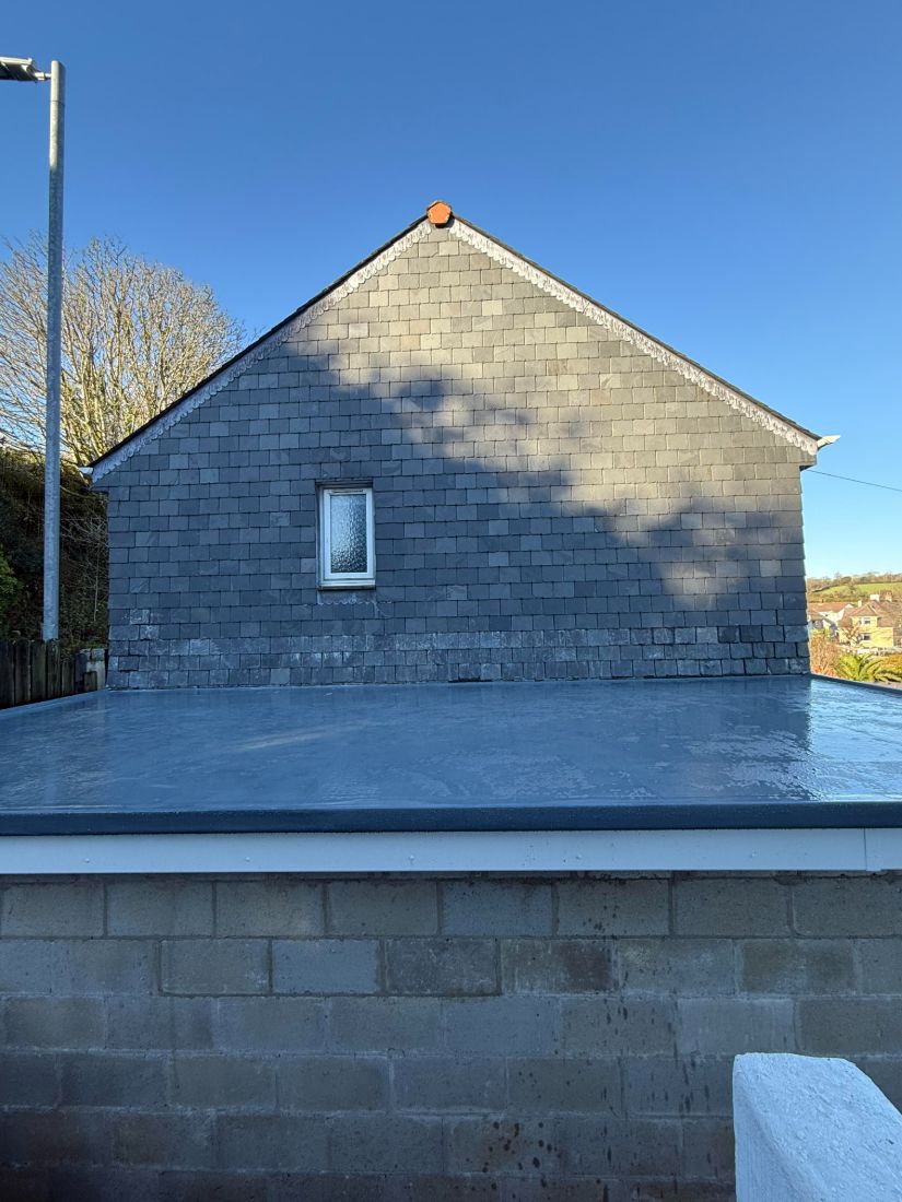 A new GRP flat roof on an extension with slate replaced on the gable to make it watertight