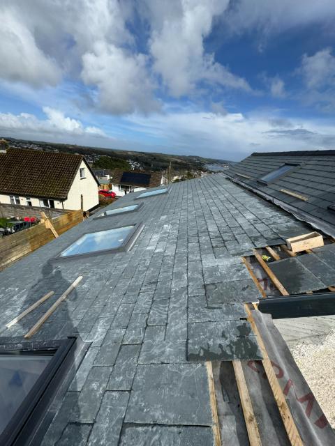 A pitched roof laid in natural slate with Velux roof windows
