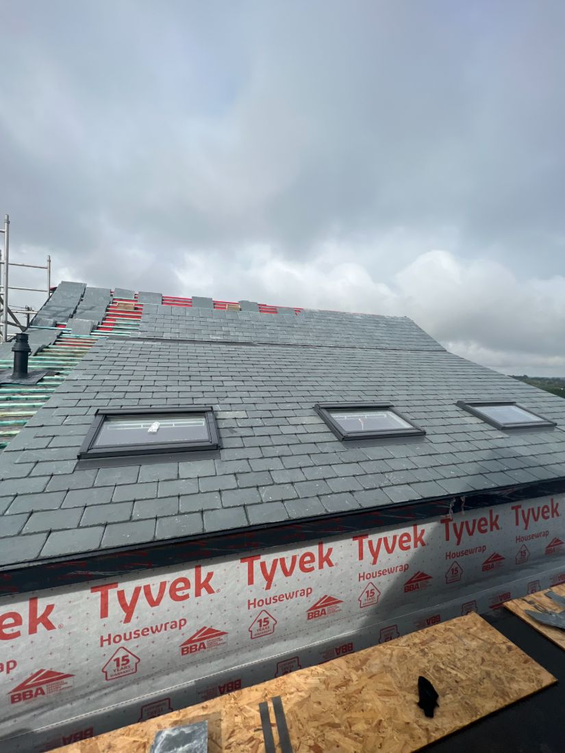 A pitched roof stripped back to breathable membrane and new battens partway through a re-roof