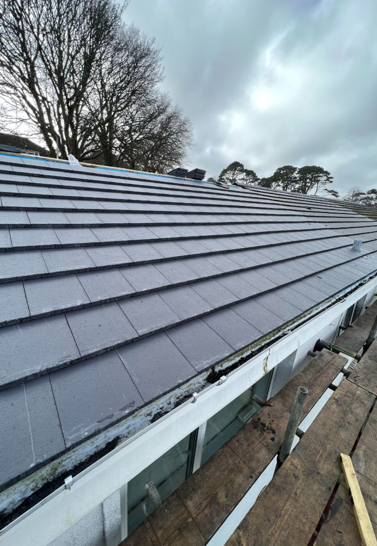 A new grey tile roof neatly joined into the neighbour's existing roof